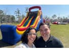 Owners of Sky High Party Rentals standing in front of 60ft Obstacle
