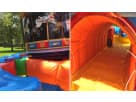Circus-themed obstacle course rental in Houston featuring orange tunnel crawl and clown artwork, ideal for carnival parties